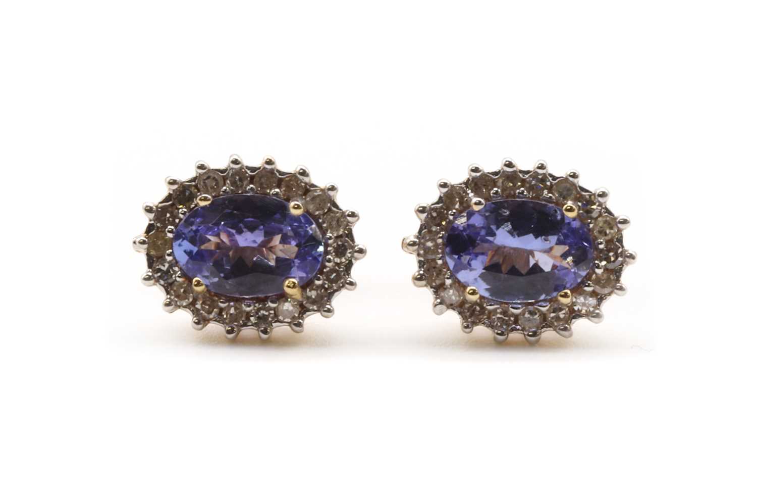Lot 224 - A pair of gold tanzanite and diamond cluster earrings