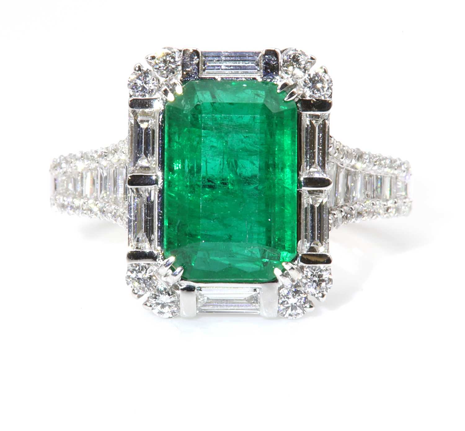 Lot 468 - A white gold emerald and diamond cluster ring