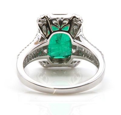 Lot 468 - A white gold emerald and diamond cluster ring