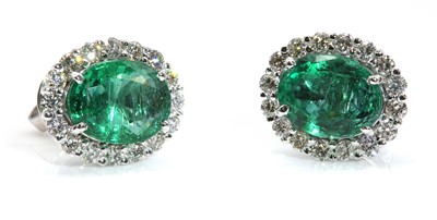 Lot 469 - A pair of 18ct white gold emerald and diamond cluster earrings