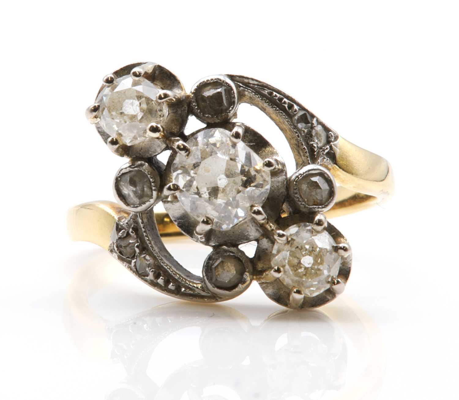 Lot 90 - A French Art Nouveau three stone diamond crossover ring
