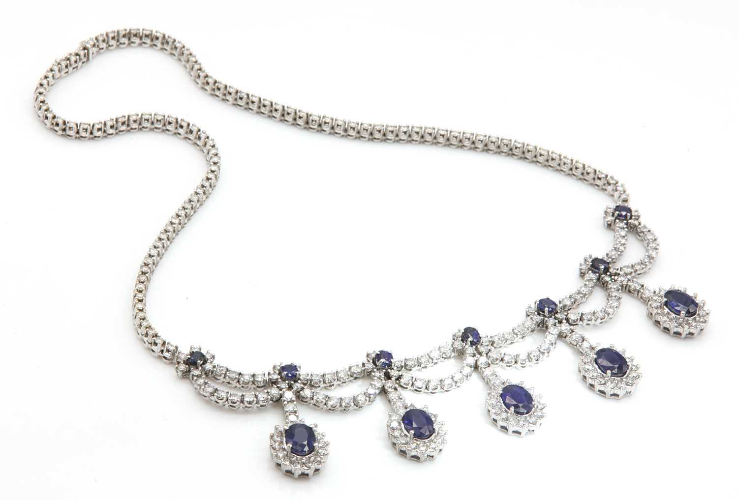Lot 428 - An Italian white gold sapphire and diamond swag and fringe necklace