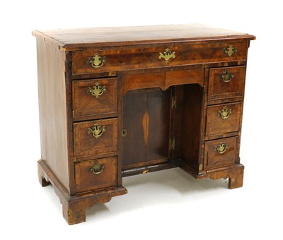 Lot 297 - A George I and later kneehole walnut desk.