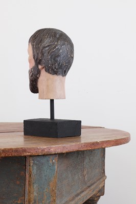 Lot 200 - A carved and painted wooden head of a saint
