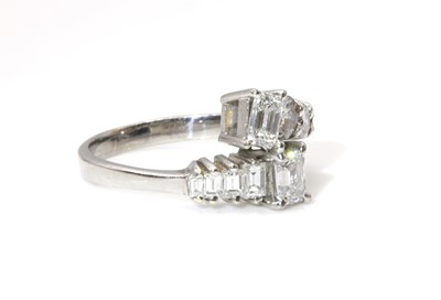 Lot 370 - An 18ct white gold two stone emerald cut diamond crossover ring