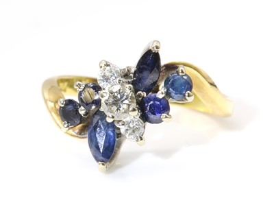 Lot 411 - A diamond and sapphire spray crossover ring, c.1980