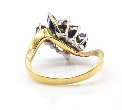 Lot 411 - A diamond and sapphire spray crossover ring, c.1980