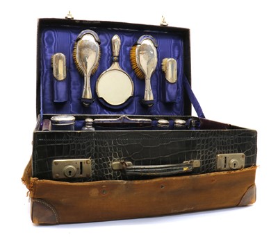 Lot 54 - An Edwardian crocodile skin suitcase with a silver vanity set