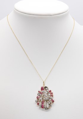 Lot 192 - A calibre ruby, synthetic ruby and diamond scroll pendant, c.1935