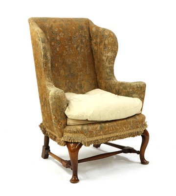 Lot 324 - A Queen Anne style walnut wing back armchair