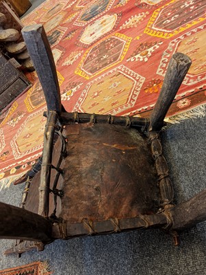 Lot 77 - A tribal hardwood and hide low chair