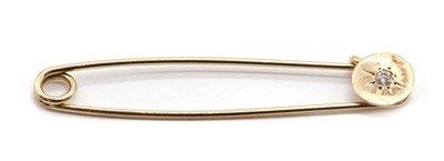 Lot 471 - A gold diamond set safety pin style brooch