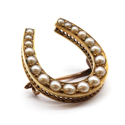 Lot 27 - A gold split pearl horseshoe brooch