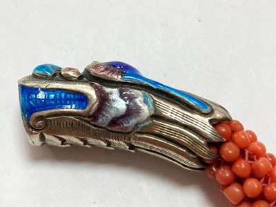 Lot 86 - A Chinese silver enamel and coral bead bangle