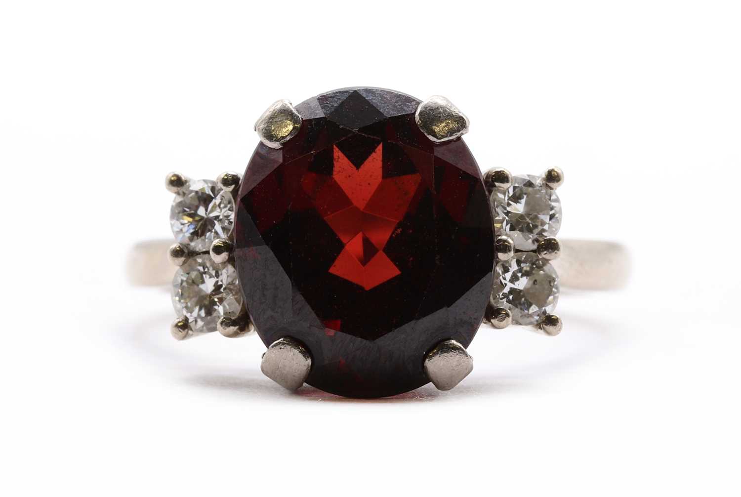 Lot An 18ct white gold garnet and diamond ring