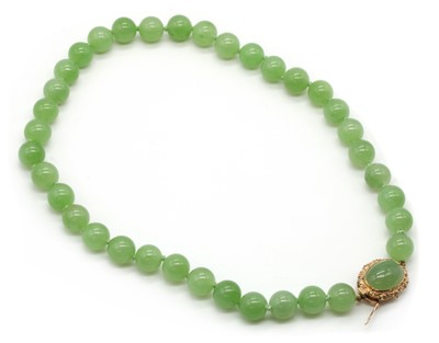 Lot 242 - A single row uniform nephrite jade bead necklace