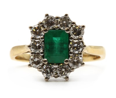 Lot 231 - An 18ct gold emerald and diamond cluster ring
