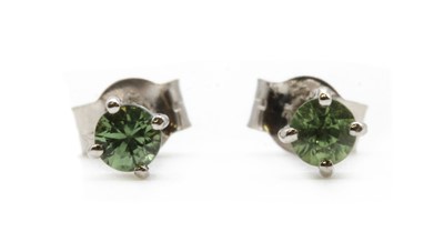 Lot 250 - A pair of 9ct white gold single stone green sapphire stud earrings