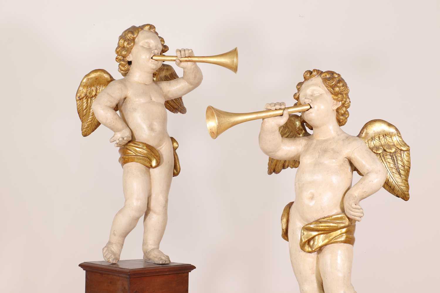 Lot 76 - A pair of painted and parcel-gilt wooden putti