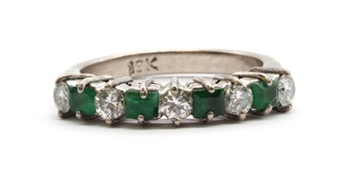 Lot 137 - A white gold diamond and emerald half eternity ring