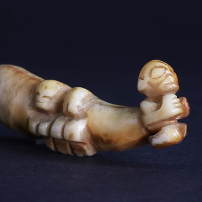 Lot 74 - A boar's tusk/tooth ear pendant 'Ha'akai' with three 'Tiki figures'