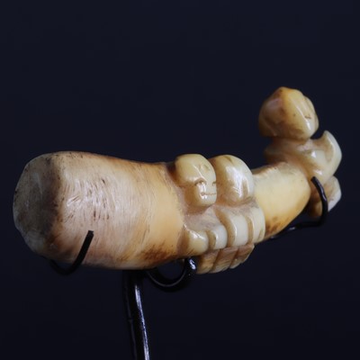 Lot 74 - A boar's tusk/tooth ear pendant 'Ha'akai' with three 'Tiki figures'
