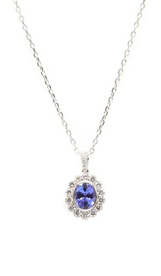 Lot 175 - A white gold tanzanite and diamond cluster pendant