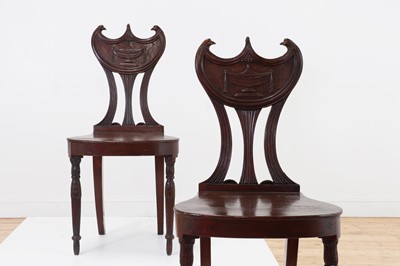 Lot 114 - A pair of George III mahogany 'pelta-back' hall chairs