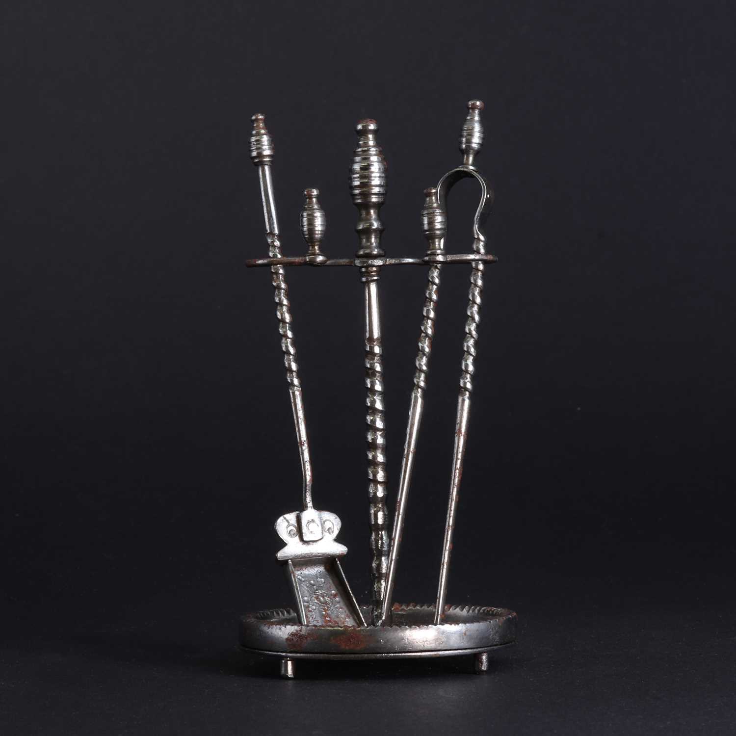 Lot 177 - A set of miniature polished steel fire irons and stand