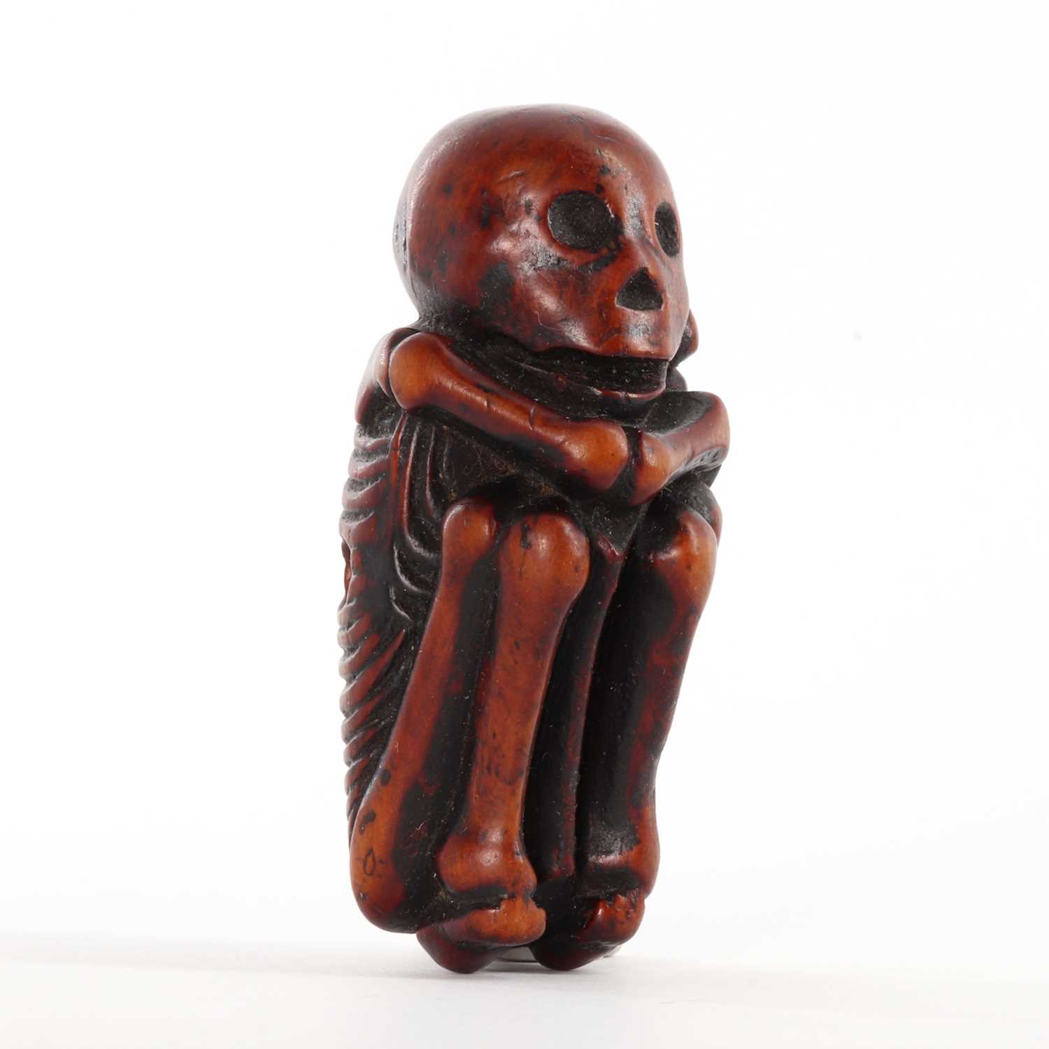 Lot 118 - A Japanese carved boxwood netsuke depicting a skeleton
