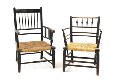 Lot 102 - Two ebonised oak 'Sussex' armchairs