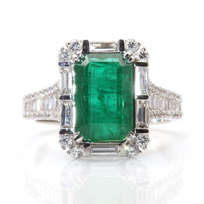 Lot 257 - A white gold emerald and diamond cluster ring