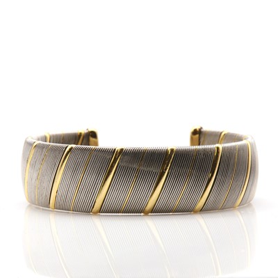 Lot 328 - A steel and gold torque bangle, by Cartier