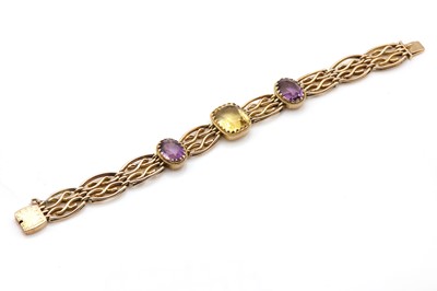 Lot 24 - An Edwardian four row citrine and amethyst gate bracelet