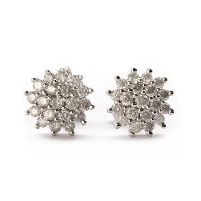 Lot 1179 - A pair of white gold diamond cluster earrings