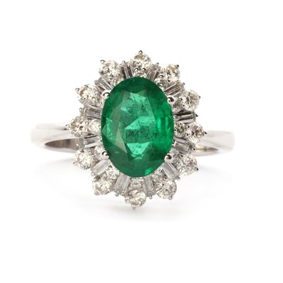 Lot 1227 - A white gold emerald and diamond cluster ring