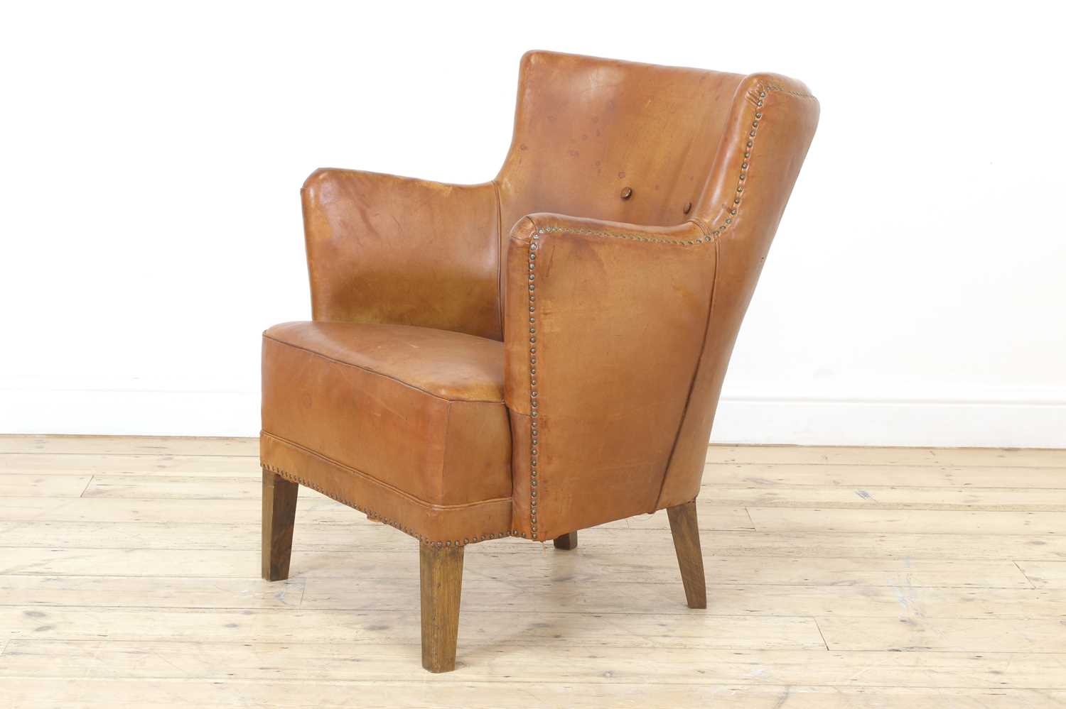 Lot 158 - A tan leather armchair