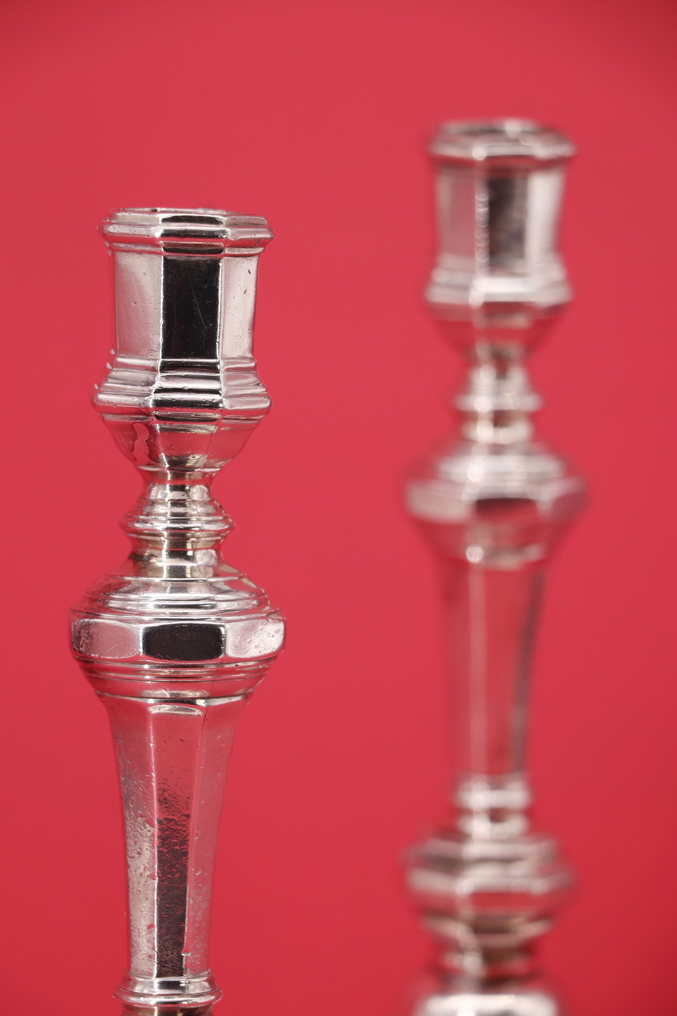 Lot 71 A near pair of cast silver candlesticks,