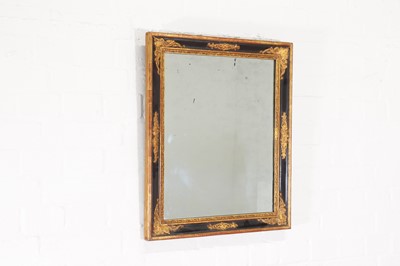 Lot 73 - An ebonised and parcel-gilt mirror