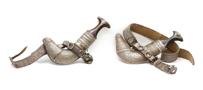 Lot 78 - A near pair of Omani silver mounted Khunjar daggers