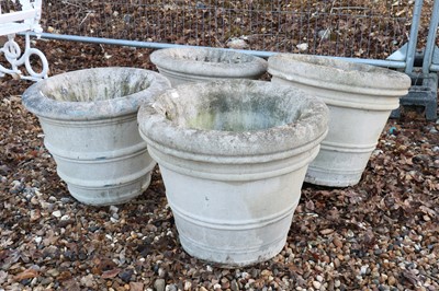 Lot 486 - A set of four medium sized reconstituted stone urns