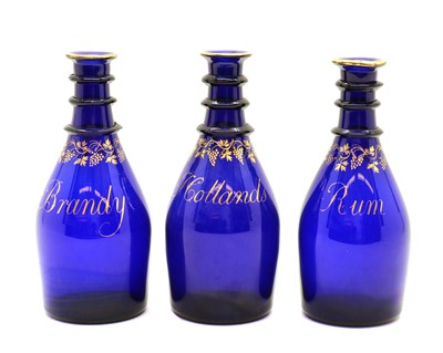 Lot 266 - A set of three Bristol blue Regency glass decanters