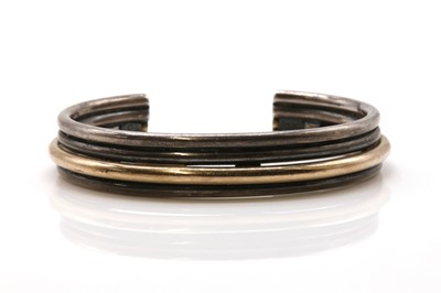 Lot 484 - A four row two colour torque bangle, by Carl Antonsen