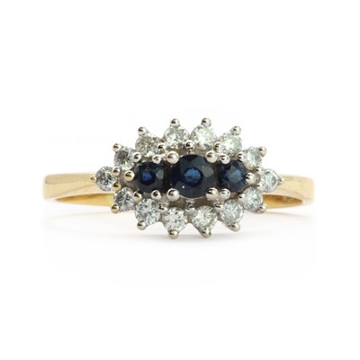 Lot 85 - An 18ct gold three stone sapphire and diamond cluster ring