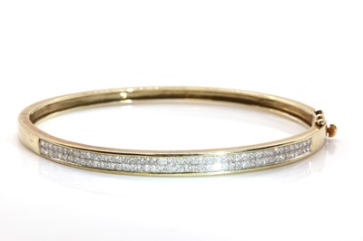 Lot 278 - A 9ct gold diamond set hinged bangle