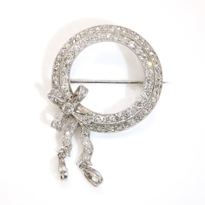 Lot 147 - An Art Deco diamond set circle and bow brooch, c.1925