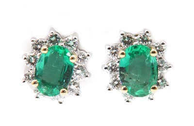 Lot 255 - A pair of 18ct gold emerald and diamond oval cluster earrings