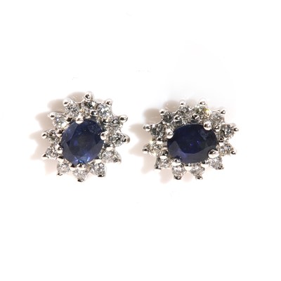 Lot 302 - A pair of white gold sapphire and diamond oval cluster earrings