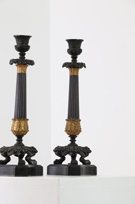 Lot 646 - A pair of Regency bronze and painted gilt candlesticks