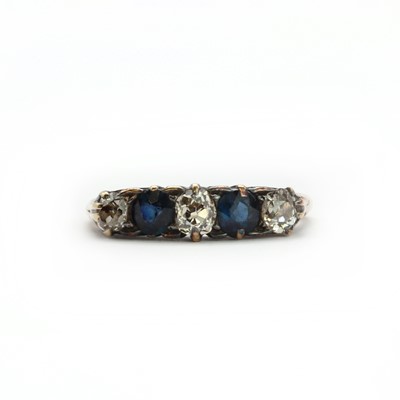 Lot 18 - A gold diamond and sapphire five stone carved head ring